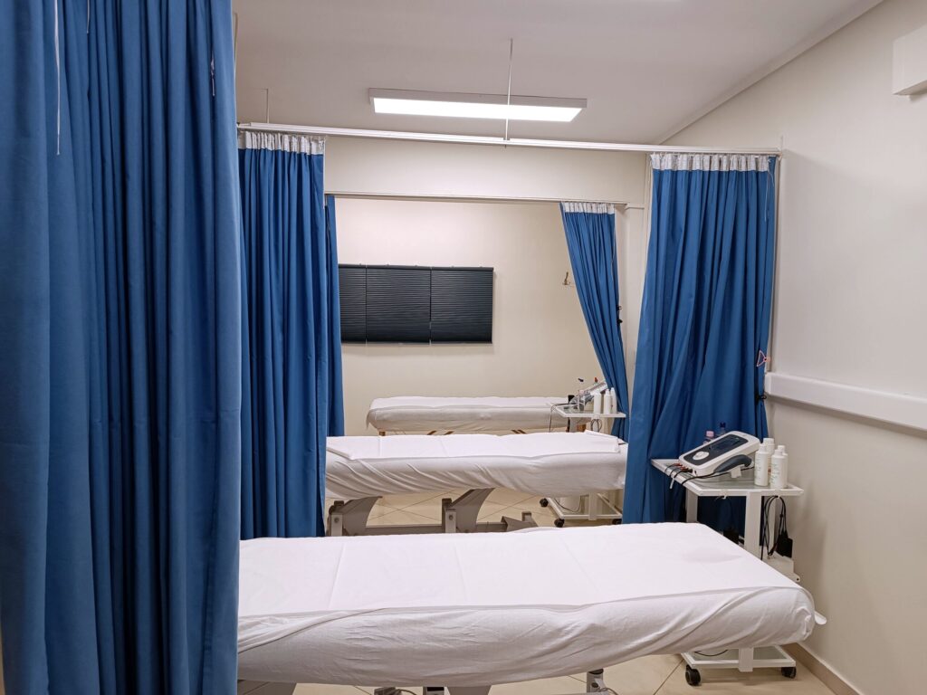 Χώρος θεραπείας του KOSMOTHERAPY με κρεβάτια και μπλε κουρτίνες